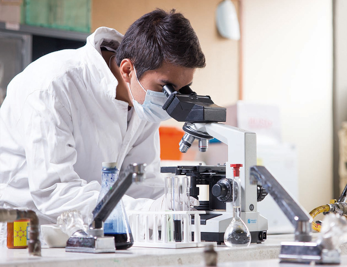 Estudiante con microscopio de laboratorio de química